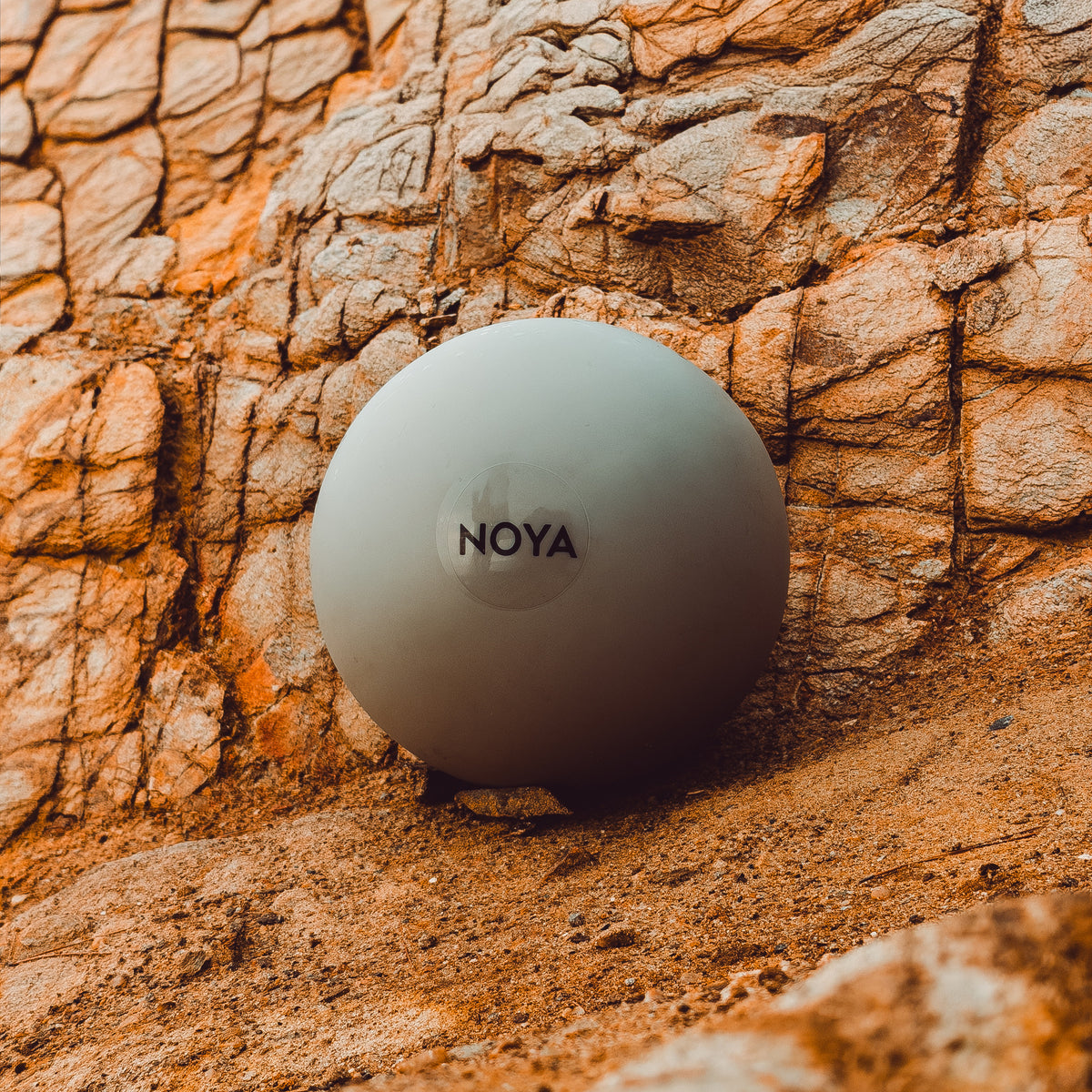 NOYA Engage Ball su una roccia arancione illuminata dal sole a Ibiza — foto di Dimitri