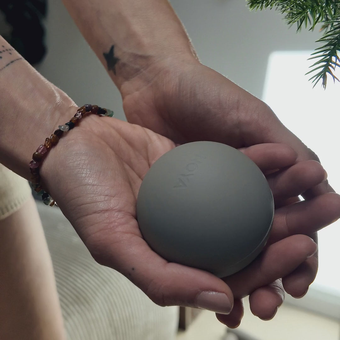 NOYA Release Ball held in the hand, showing its size